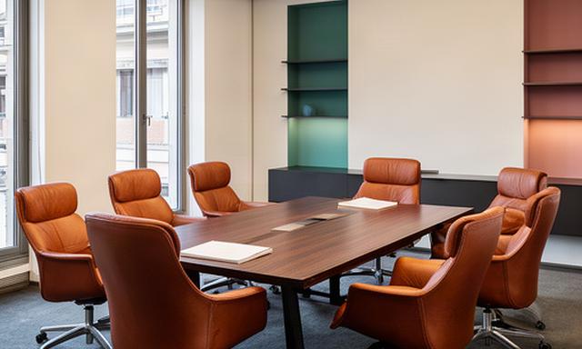 Sala riunioni a Milano con sei poltrone ergonomiche in pelle attorno a un tavolo in legno